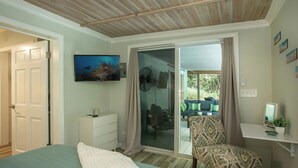 A bedroom with a bed, a TV, a sliding glass door to a balcony, and a chair. - Villa de Paz, STJ 4 BR/2.5B, 2-8 guests Pool Private Renovated AC backup power (St John)