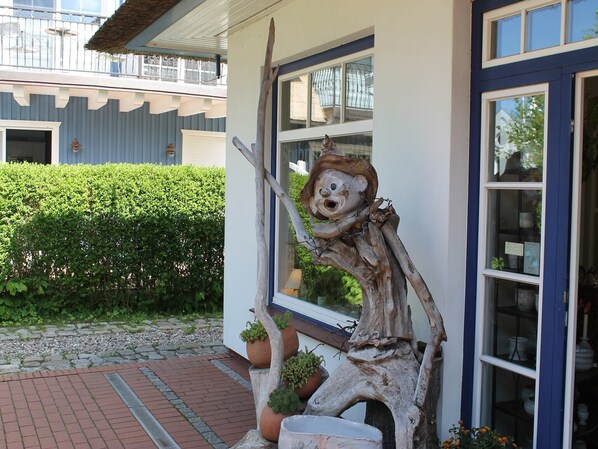 A building with a blue exterior and a wooden sculpture on the porch.