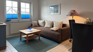 A furnished living room with a sofa, a coffee table, a lamp, and a chair.