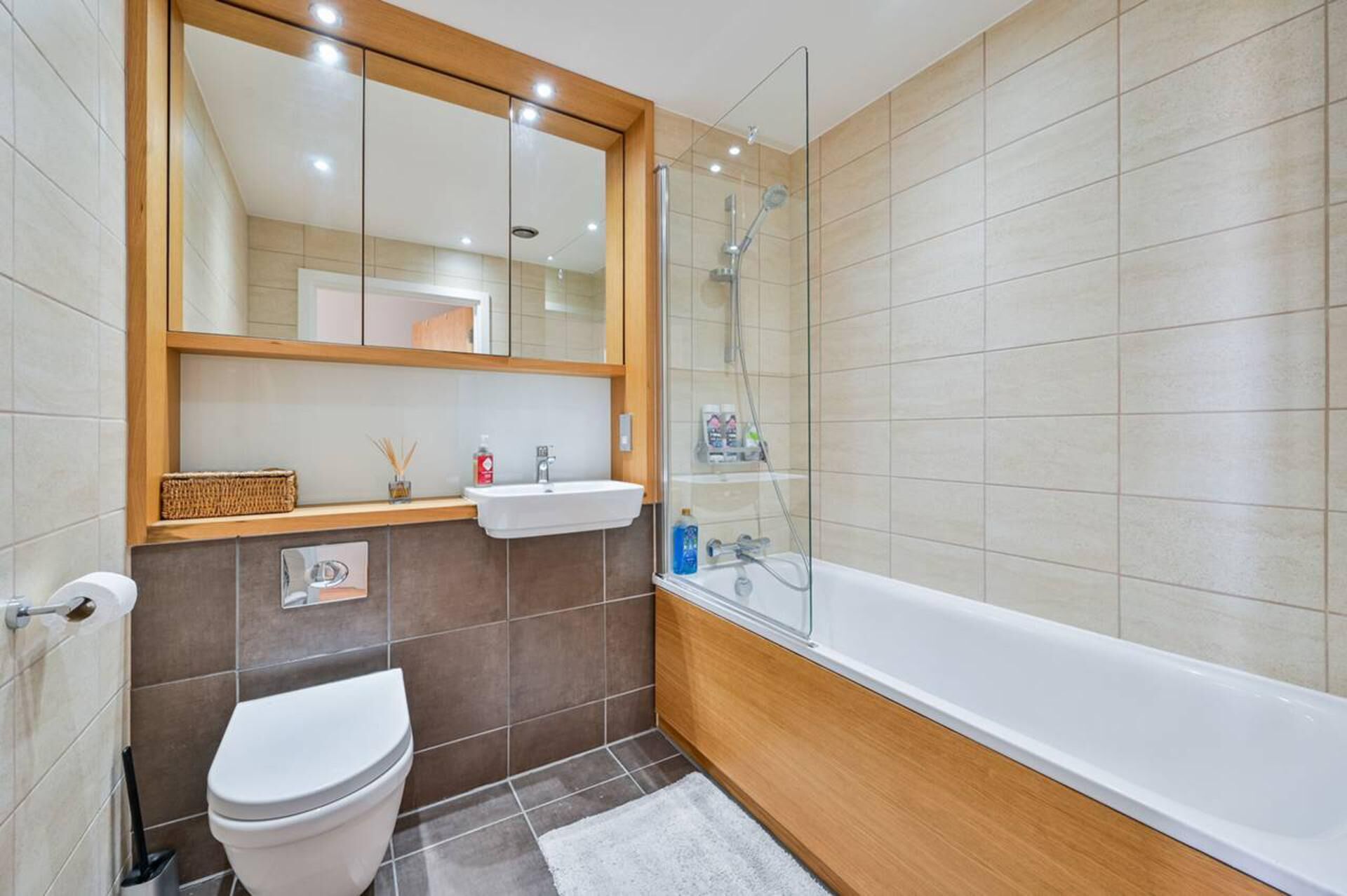 A modern bathroom with a toilet, sink, and shower.