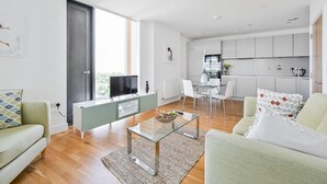 Een modern appartement met een woonkamer, eethoek en keuken.