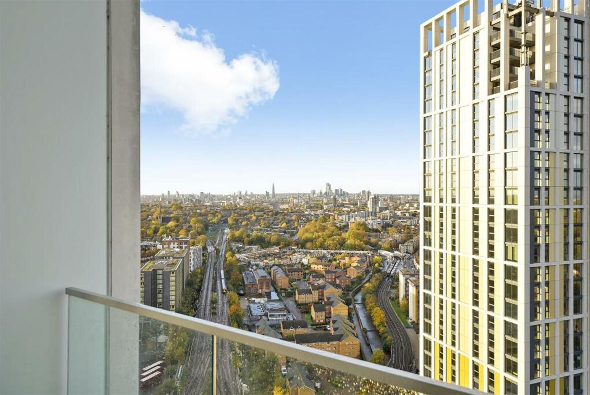 A high-rise building with a view of a cityscape, including a river and various buildings.