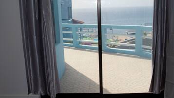 A room with a view of the ocean through a large window.