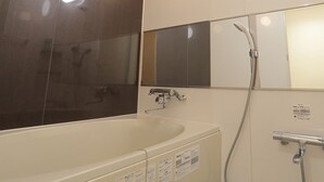 Un baño moderno con bañera, ducha y espejo.