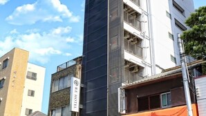 Un hotel con fachada moderna, varios pisos y un cartel que indica que es un hotel.