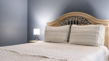 A bed with a wooden headboard, two pillows, and a bedside lamp.