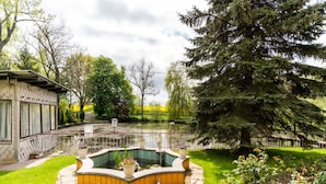 A garden with a pond, a gazebo, and a large tree. - Vacation Home with Pond (Klein Pravtshagen)
