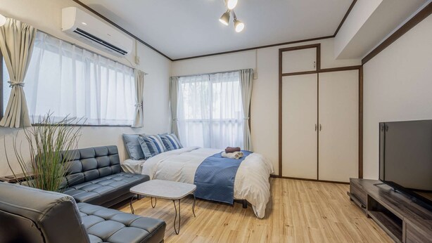 A modern bedroom with a bed, a sofa, a TV, and a wooden floor. - Near Shibuya station!　　One stop (2 minutes) by train, 8 minutes walk to Ikejiri-Ohashi Station! (世田谷区)
