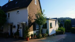 Ein zweigeschossiges Haus mit Ziegel Fassade und geneigtem Dach.