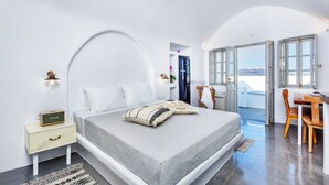 A modern bedroom with a bed, bedside table, and a view of the outdoors.