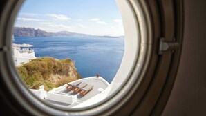 A view from an airplane window of a coastal area with white buildings and a body of water. - Suite with Caldera View (Santorini)