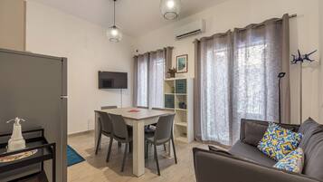 Apartment, City View | Living area | 32-inch flat-screen TV with cable channels