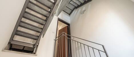 A staircase with metal railings and a wooden door at the top.