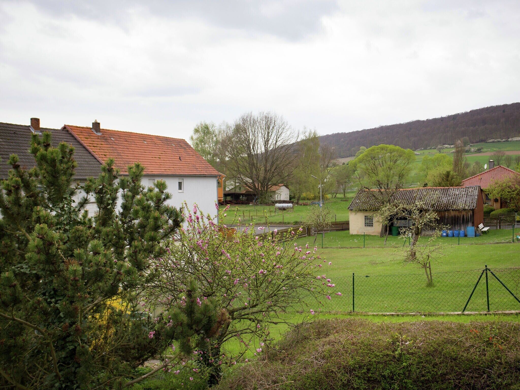 Paisatge rural amb cases, una zona tancada i un riu.