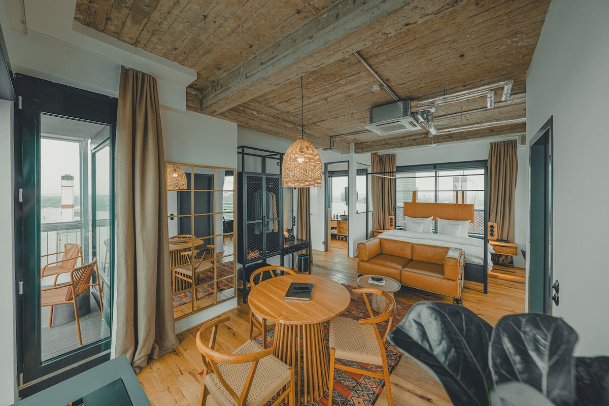 Una sala de estar moderna con techo de madera, una mesa de comedor redonda y un sofá.
