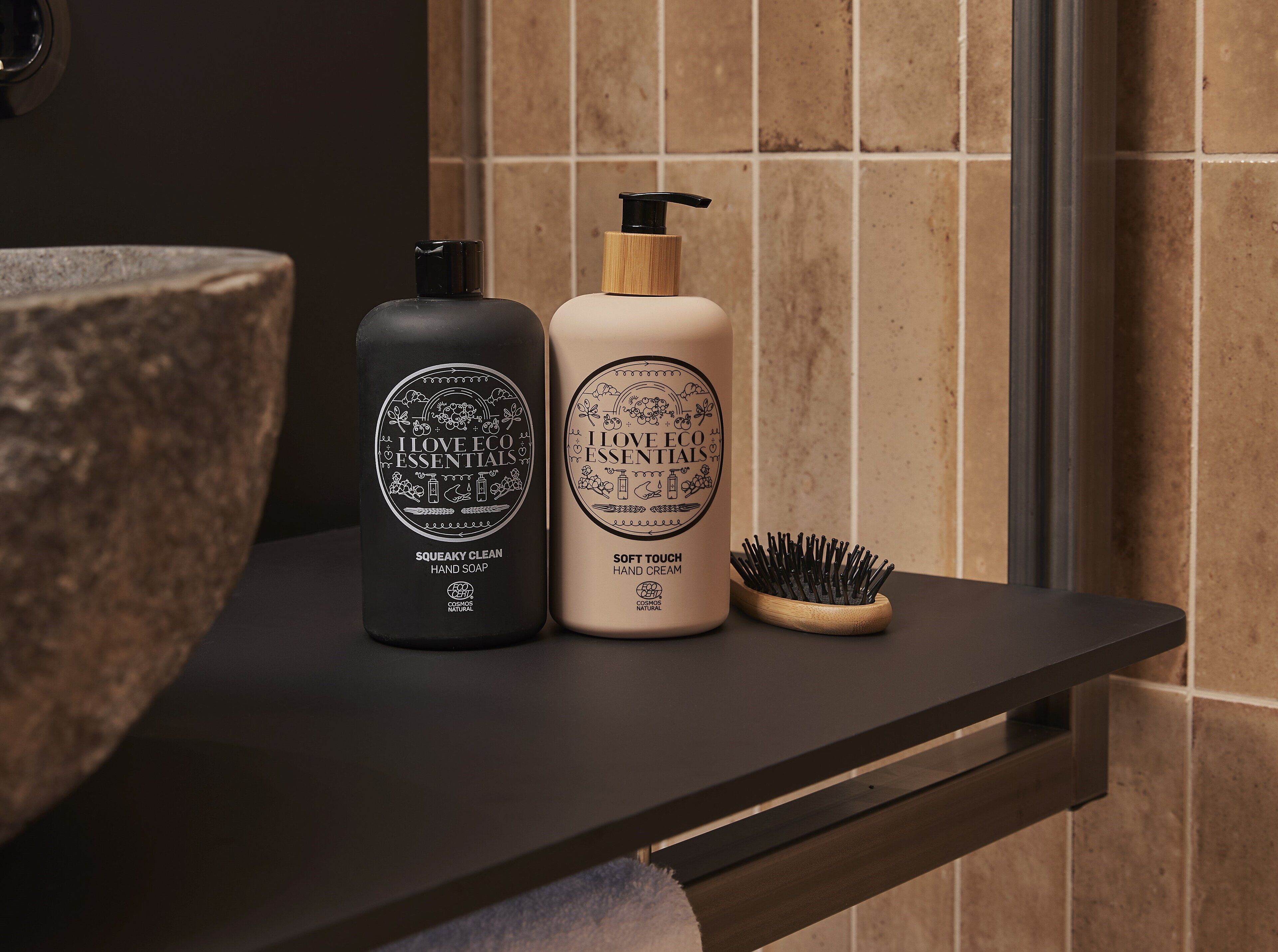 Zwei Seifenflaschen und Handcreme auf einer Badezimmerablage.