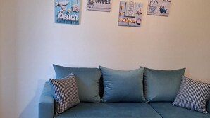 Une pièce avec un canapé et quatre éléments décoratifs sur les murs.