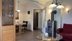 Una sala de estar moderna con una mesa de centro de vidrio, un sofá rojo y una chimenea.