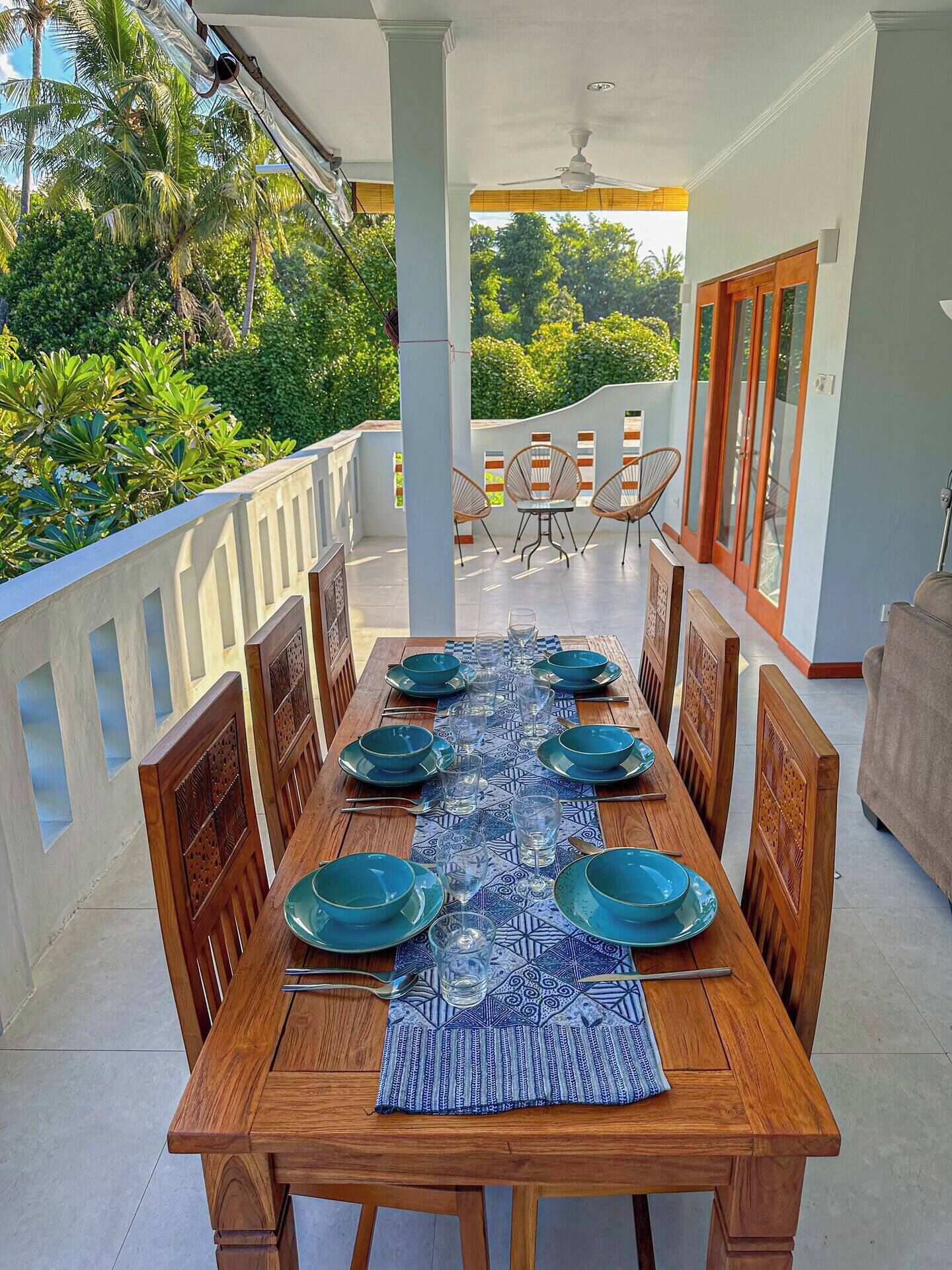 Comedor con una mesa de madera dispuesta para seis personas, rodeada de sillas de madera.
