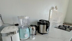 A kitchen with a toaster, a blender, a coffee maker, and a gas stove. - Rumah Diyah (Karangasem)
