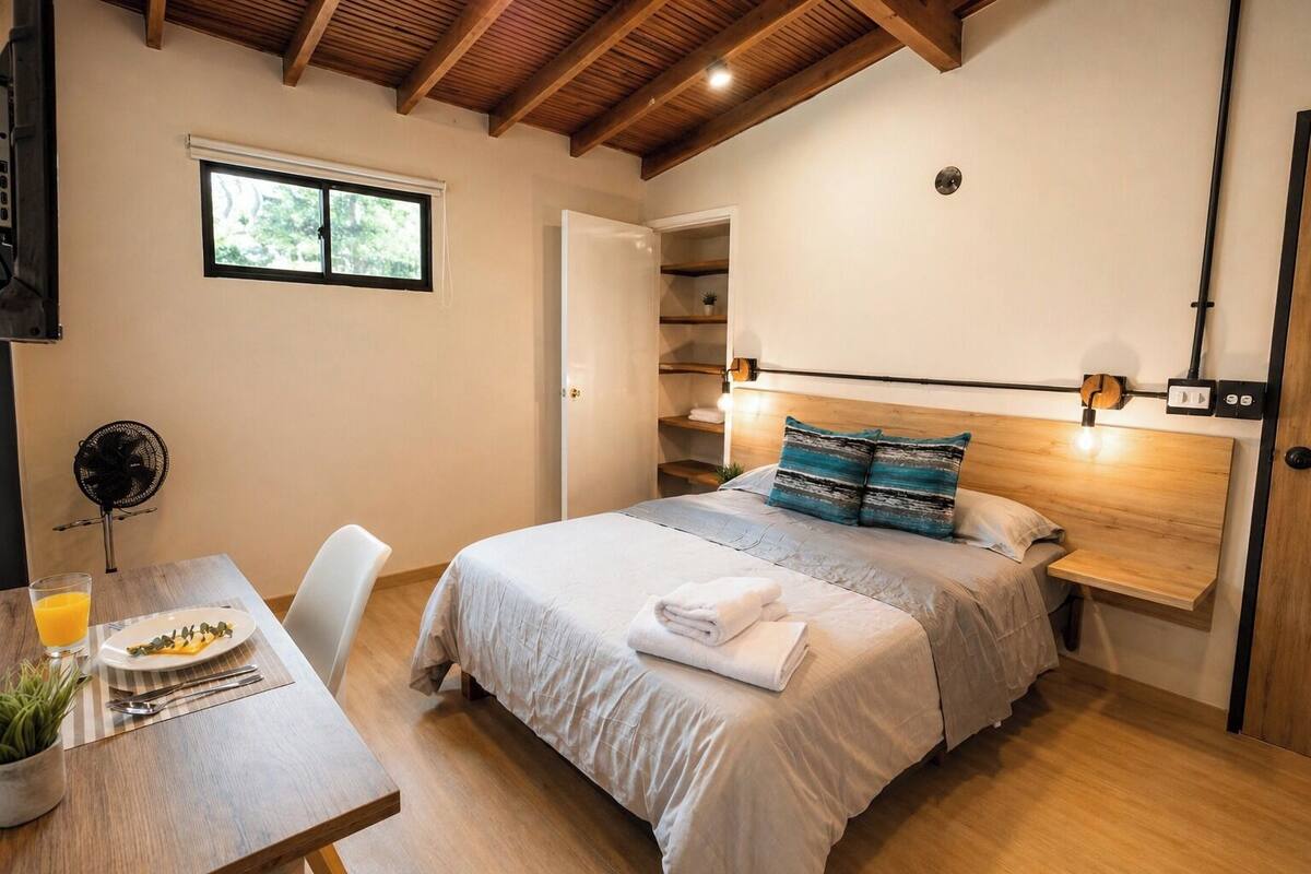 Une chambre à coucher avec un lit, une table de chevet et une fenêtre.