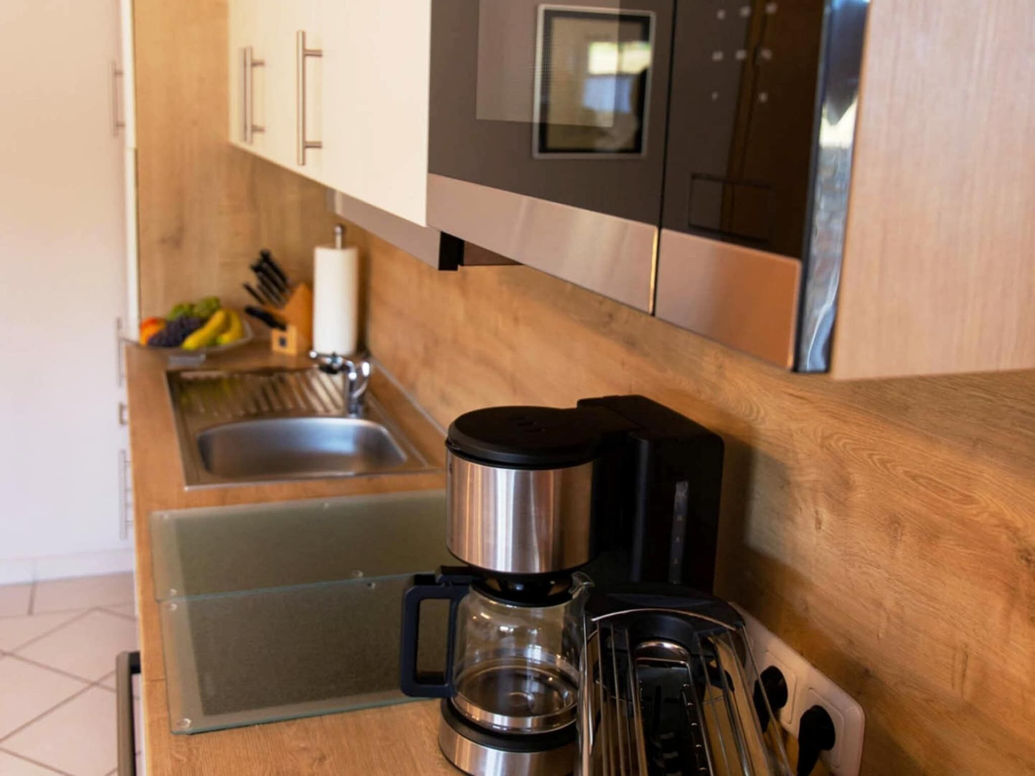 Une cuisine équipée d’une machine à café, d’un grille-pain et d’un évier.