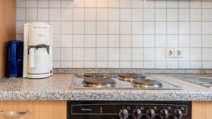 A kitchen with a built-in stove, a coffee maker, and a water dispenser. - Ferienwohnung in Ediger (Mosel) (Ediger-Eller)