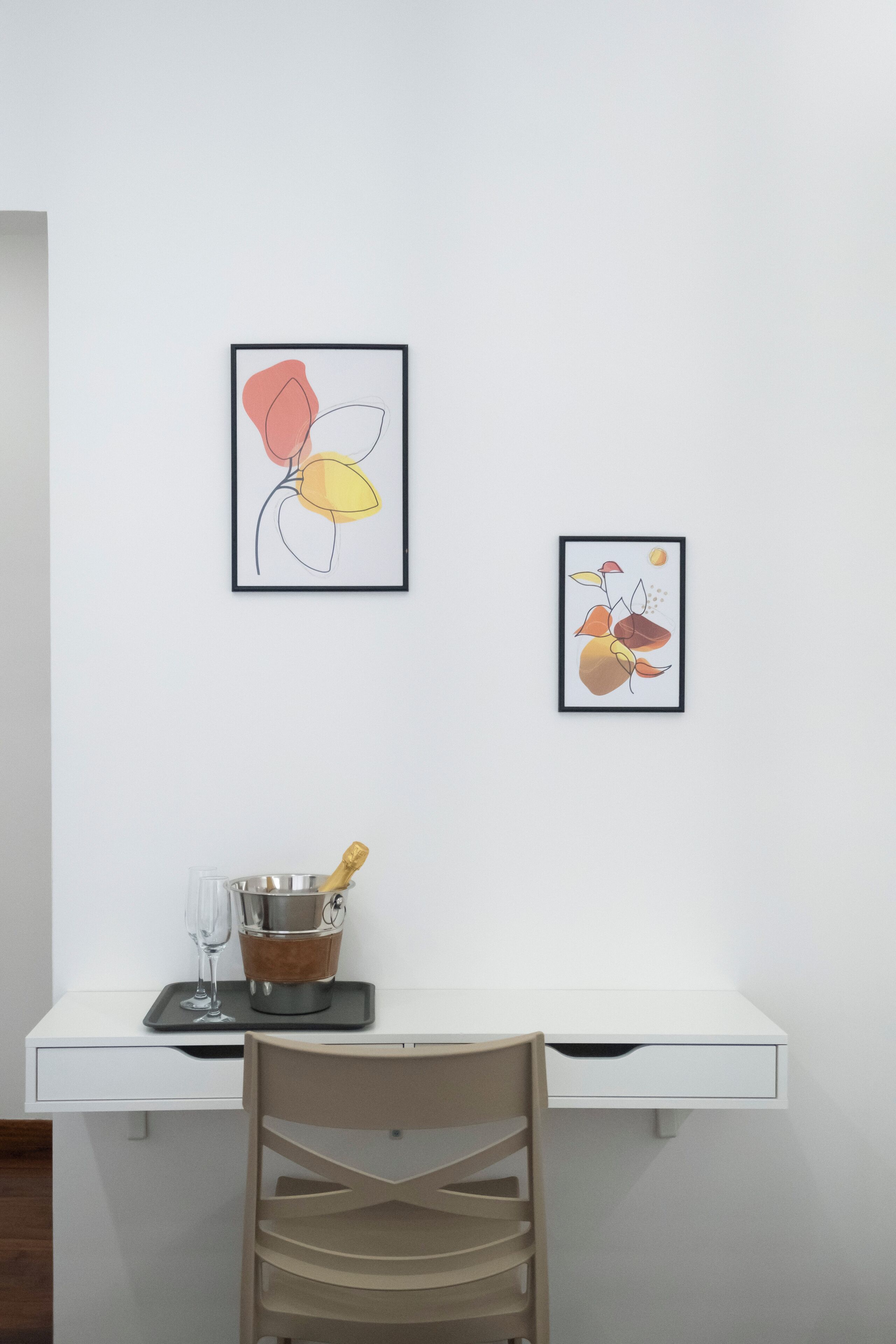 Een wit bureau met erboven een lijst met een abstract schilderij.