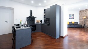 Una cocina moderna con una isla central, electrodomésticos integrados y un comedor.