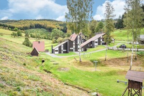 A rural setting with a modern house, a small barn, and a path leading to the house. - Ferienhaus mit herrlicher Aussicht (Bestwig-Untervalme)