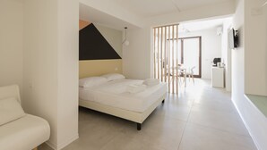 A modern bedroom with a bed, a desk, and a chair in a bright, open-plan space. - Visitsicilia Vasile 9 - 2 (Castellammare del Golfo)