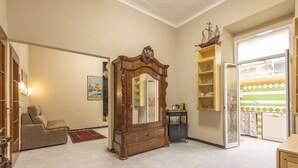 Een ruime woonkamer met een grote houten kast, een bank en een betegelde vloer.