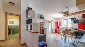 Una cocina moderna con comedor, suelo de madera y vistas al exterior.