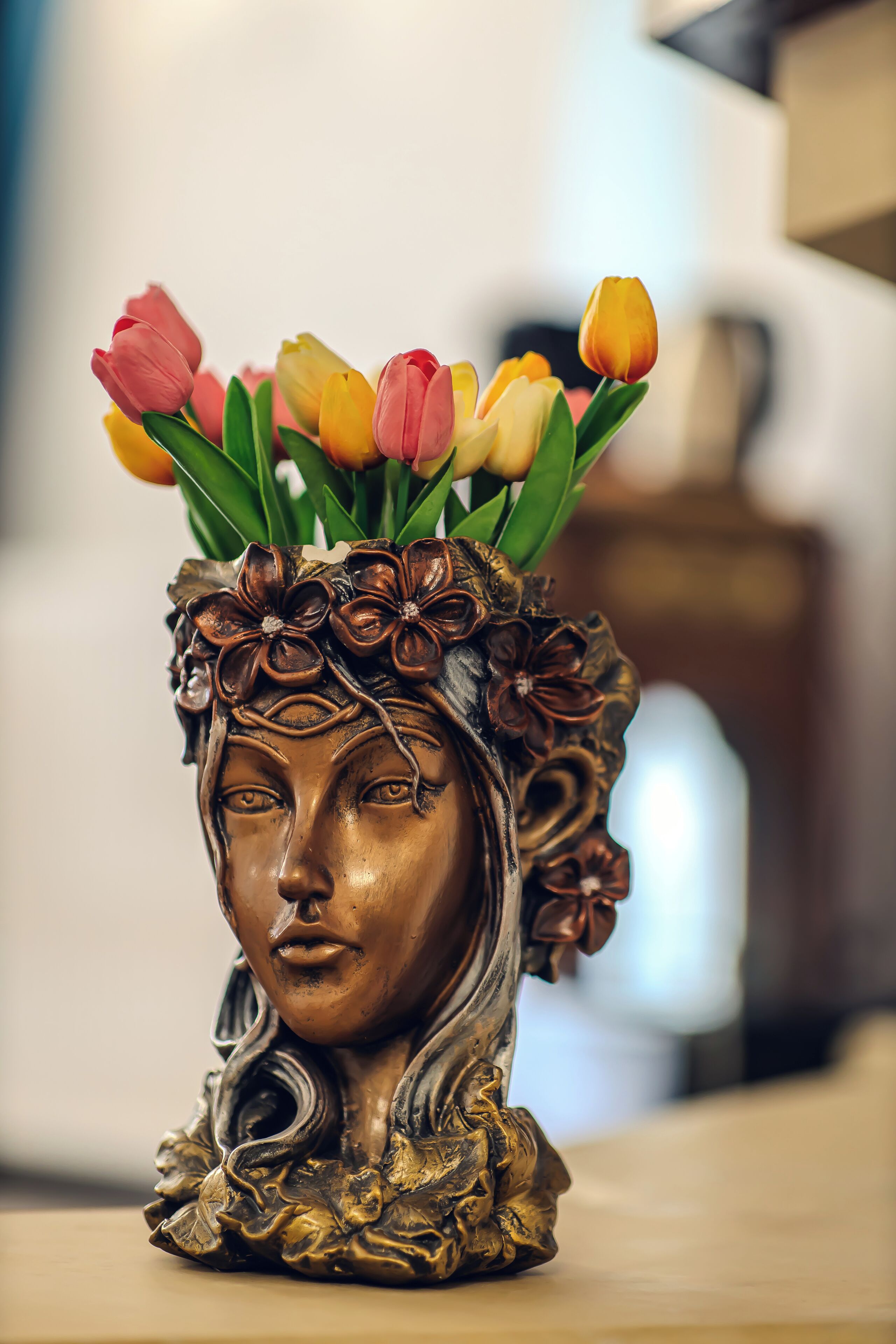 Un vase décoratif orné de motifs floraux et contenant un bouquet de tulipes.