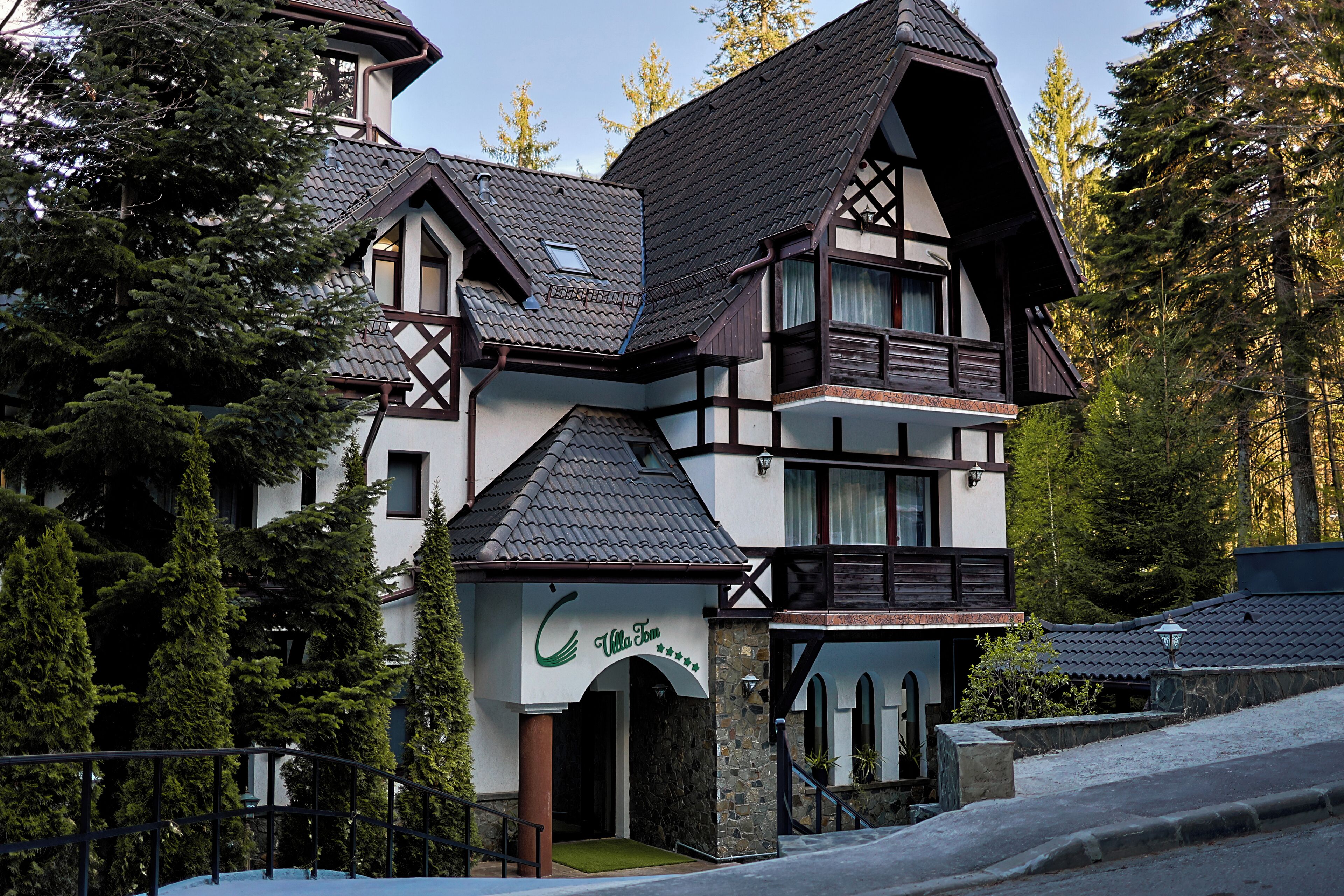 A traditional chalet-style building with a steeply pitched roof, wooden balconies, and a stone facade.