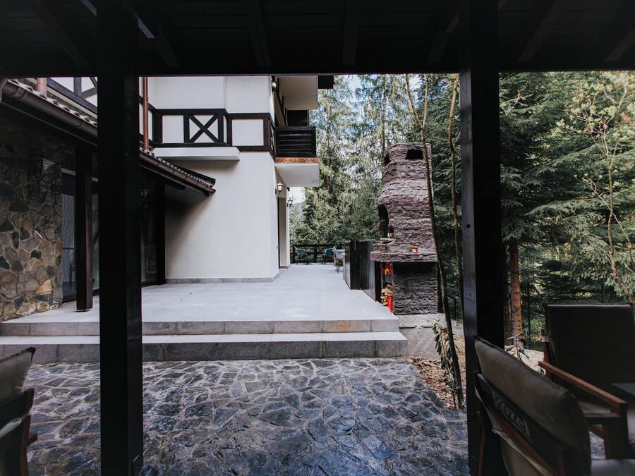 A stone pathway leading to a building with a stone facade and a wooden deck.