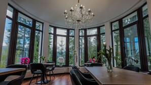 A dining area with a large table, chairs, and a chandelier.