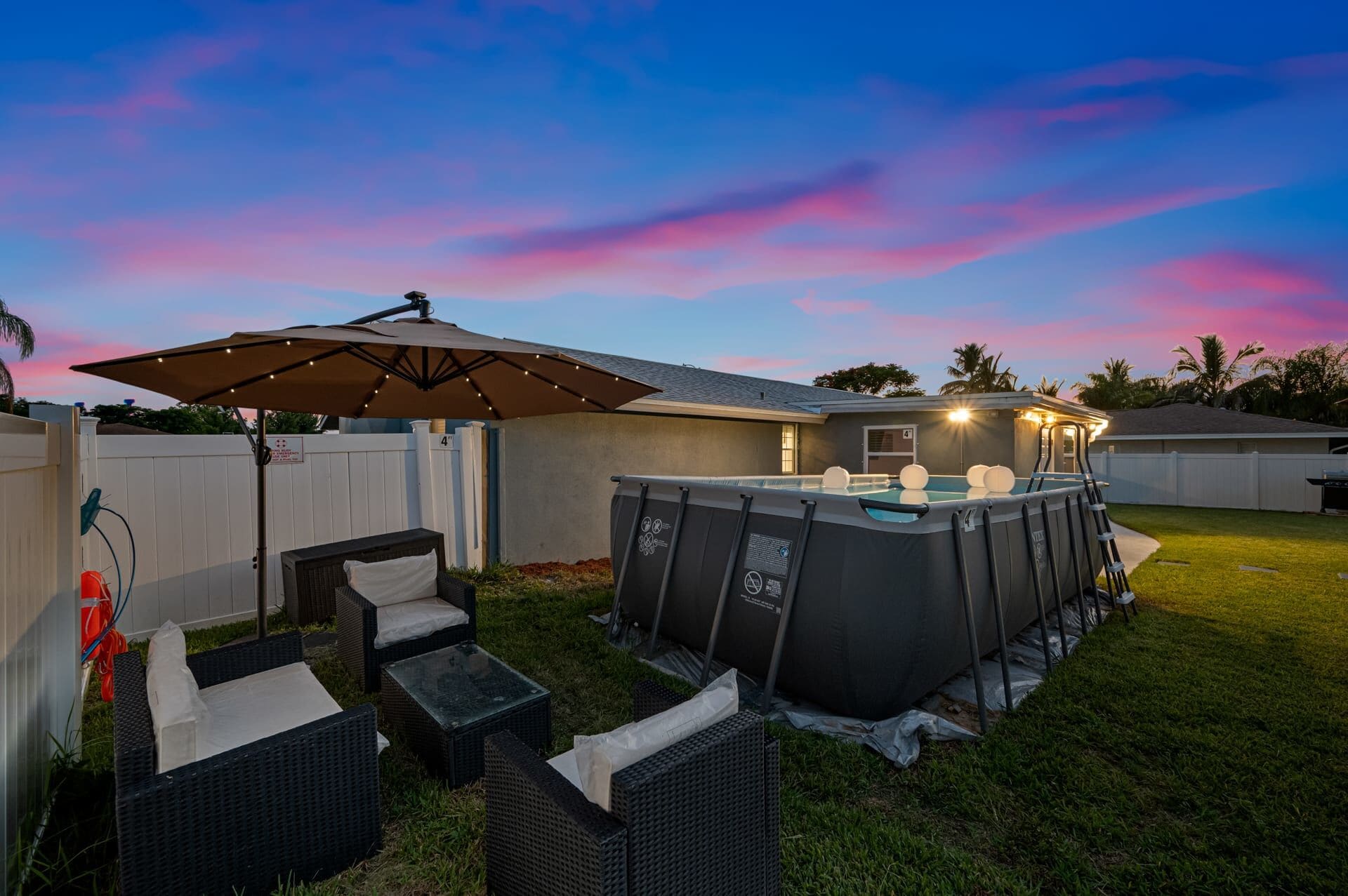 Ein Garten mit Whirlpool, Gartenmöbeln und einer überdachten Terrasse.