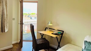 A small room with a desk, chair, and a view of buildings through a door. - Tranquil, pet friendly apartment In Norwich city centre (Norwich)