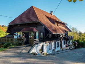 Un chalet traditionnel doté d’un toit à forte pente, d’un porche en bois et d’un petit balcon.