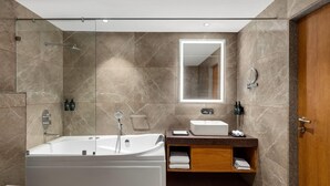 Une salle de bain moderne avec une baignoire sur pieds, un meuble-lavabo et un grand miroir.