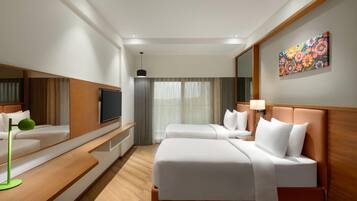 A hotel room with two beds, a flat-screen TV, a painting on the wall, and a large window with curtains.