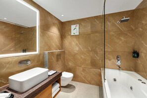 A modern bathroom with a large mirror, a rectangular sink, a toilet, and a freestanding bathtub. - Ramada Encore By Wyndham Viramgam (Viramgam)