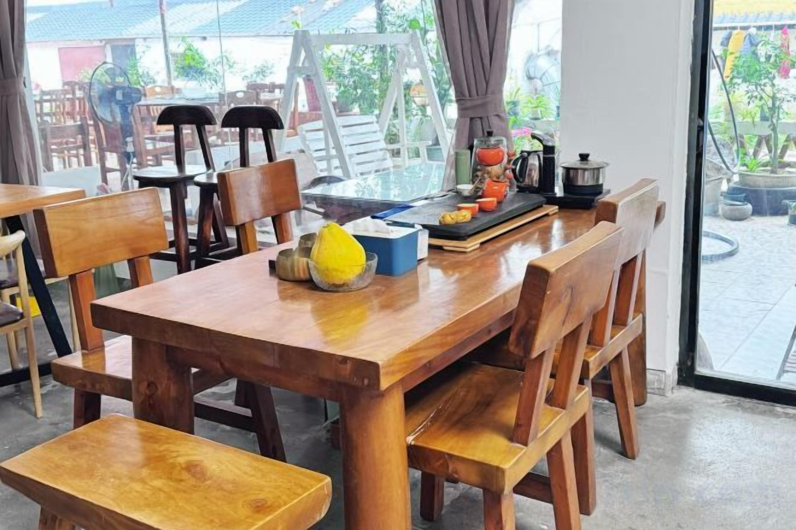 A wooden dining table with chairs, a blue container, and a yellow object on it.
