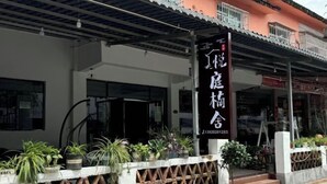 A building with a signboard and potted plants in front. - Yueting Nanshe Homestay (Renhua)