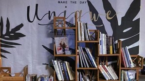 A bookshelf filled with books and a banner with motivational text. - Yueting Nanshe Homestay (Renhua)