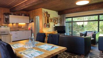 Un intérieur chaleureux comprenant un coin repas, une cuisine et un espace salon avec vue.