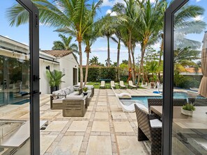 A poolside area with lounge chairs, a small pool, and palm trees.