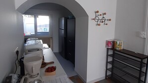 A kitchen with a white countertop, a coffee maker, a blender, and a refrigerator. There is a checkered floor and a wall-mounted light fixture. - Seaside house 6 pers. Trébeurden pink granite coast Brittany (Trébeurden)