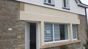 A building with a stone facade, a beige overhang, and a window with a sign. - Seaside house 6 pers. Trébeurden pink granite coast Brittany (Trébeurden)